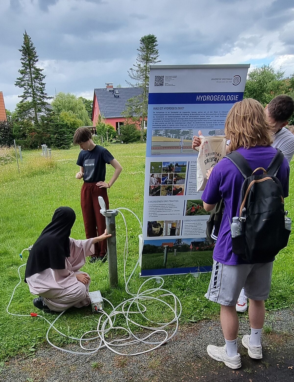 Schüler messen die Höher des Wasserstandes in einer Bohrung des Hydrogeologischen Testfeldes in Greifswald